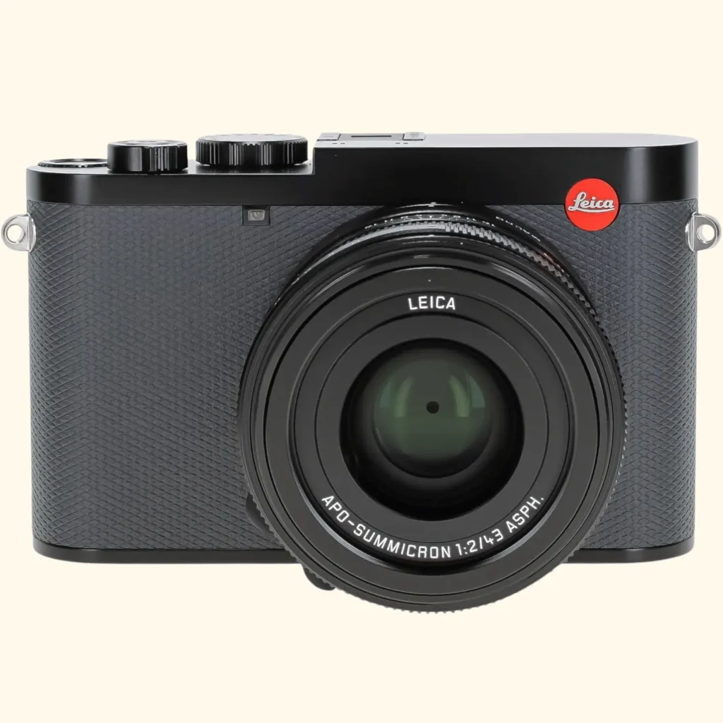 A front-facing product shot of the Leica Q3 compact full-frame camera. The camera features a classic black textured body with the iconic red Leica logo in the upper right corner and an attached APO-Summicron 1:2/43 ASPH. lens.