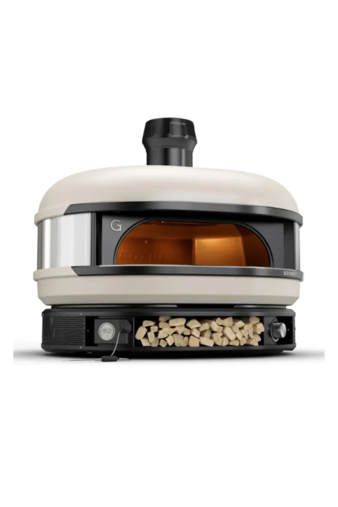 Premium Gozney Dome dual-fuel outdoor pizza oven with wood storage compartment and glowing interior, designed for professional-grade home pizza making