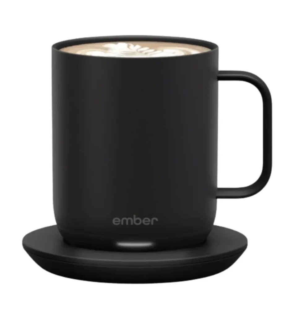 Black Ember Smart Mug 2 with charging coaster and latte art, an app-controlled heated mug that maintains perfect drinking temperature, ideal as a thoughtful viral Valentine's tech gift.