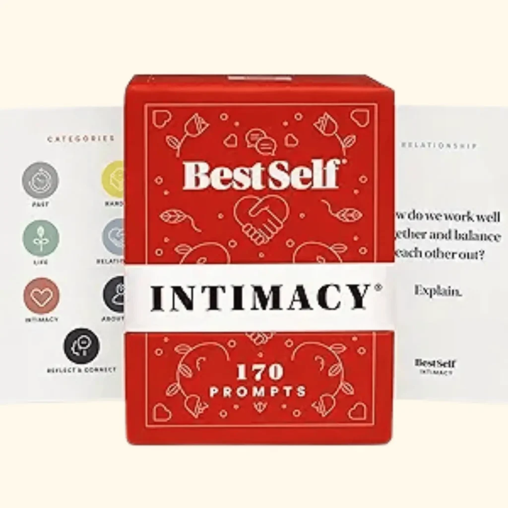 A product shot of the BestSelf Co. Intimacy Deck, featuring a red box labeled "170 Prompts". The image shows two sample cards from the deck: one displaying colorful category icons like "Life," "Intimacy," and "Relationship," and another featuring a deep-connection question: "How do we work well together and balance each other out? Explain.